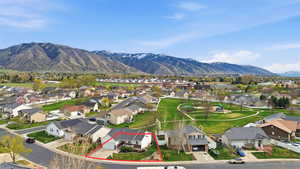 Aerial view of residential area with property parcel outlined and a mountainous background