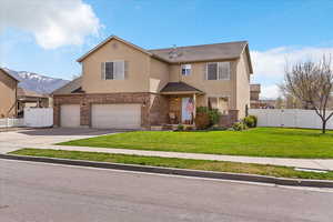 Traditional home with a gate, a garage, and brick siding