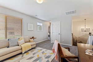 Living room with light carpet and suspended lighting