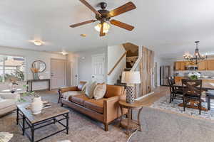Living room featuring hanging lights, light wood finished floors, and a ceiling fan