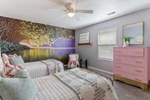 Bedroom with an accent wall, carpet, and ceiling fan