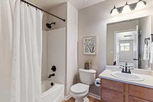Full bath with vanity, shower / tub combo, and a textured wall
