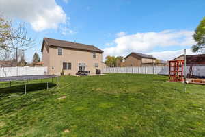 Back of property featuring a trampoline, a fenced backyard, a patio area, and stucco siding