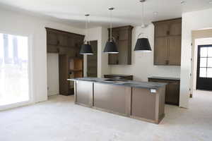 Kitchen with a kitchen island, decorative light fixtures, and dark wood finish cabinetry
