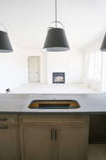 Kitchen with a glass covered fireplace, wood finish cabinets, light stone countertops, and open floor plan