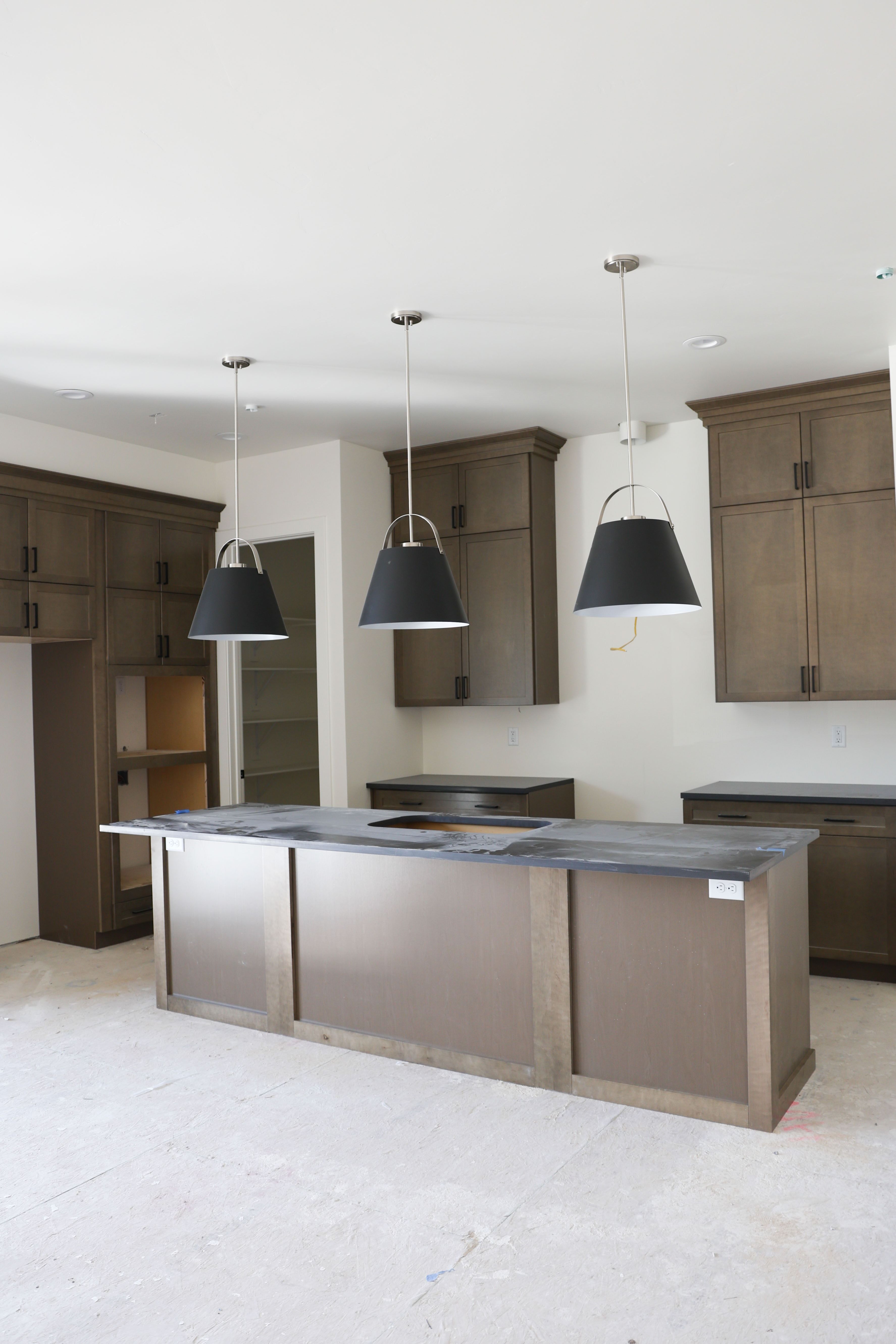 Kitchen featuring a kitchen island, hanging light fixtures, and dark wood finish cabinetry