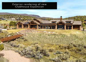 Rear view of property with stone siding, a mountain view, a patio area, and a chimney