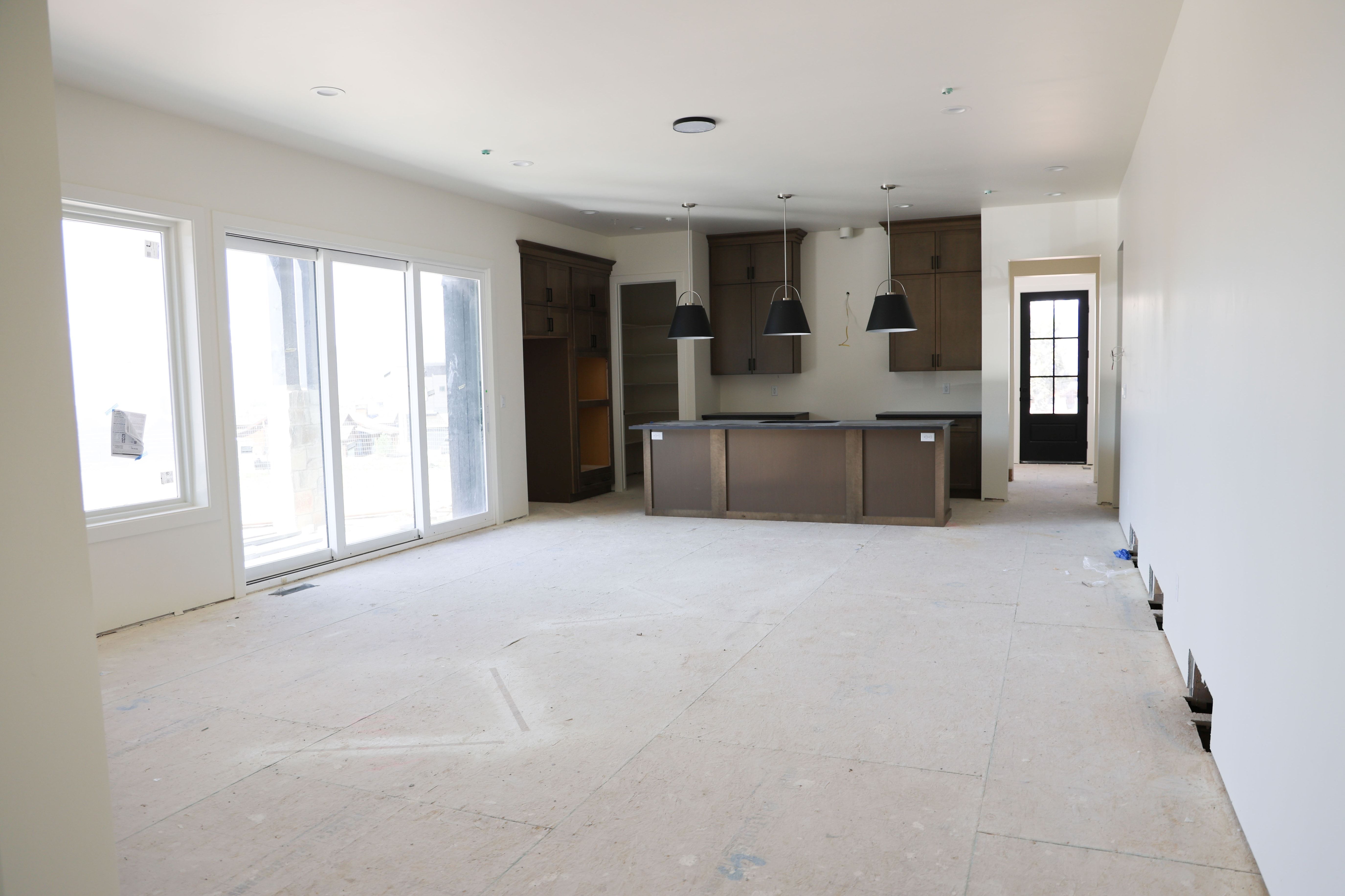 Kitchen featuring a center island, decorative light fixtures, open floor plan, dark countertops, and dark wood finish cabinets