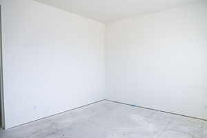 Unfurnished room featuring concrete flooring