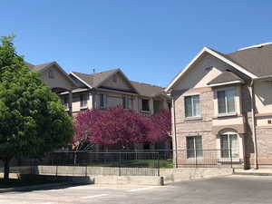 View of front of house featuring a fenced front yard, stucco siding, and brick siding