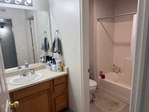 Bathroom featuring vanity, bathtub / shower combination, and light tile patterned flooring