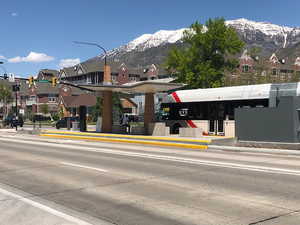 View of concrete road with sidewalks, traffic lights, curbs, and a mountain view