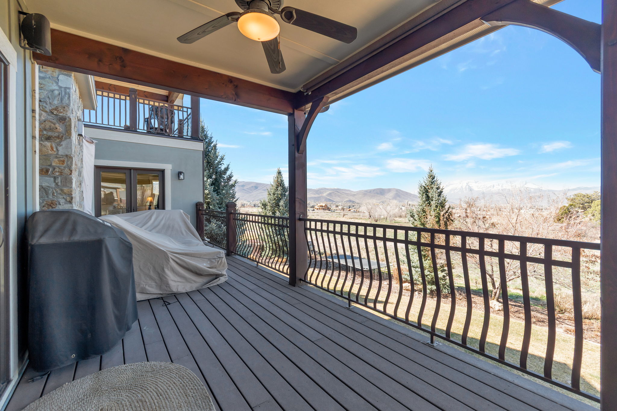 Wooden deck featuring a ceiling fan, grilling area, and a mountain view