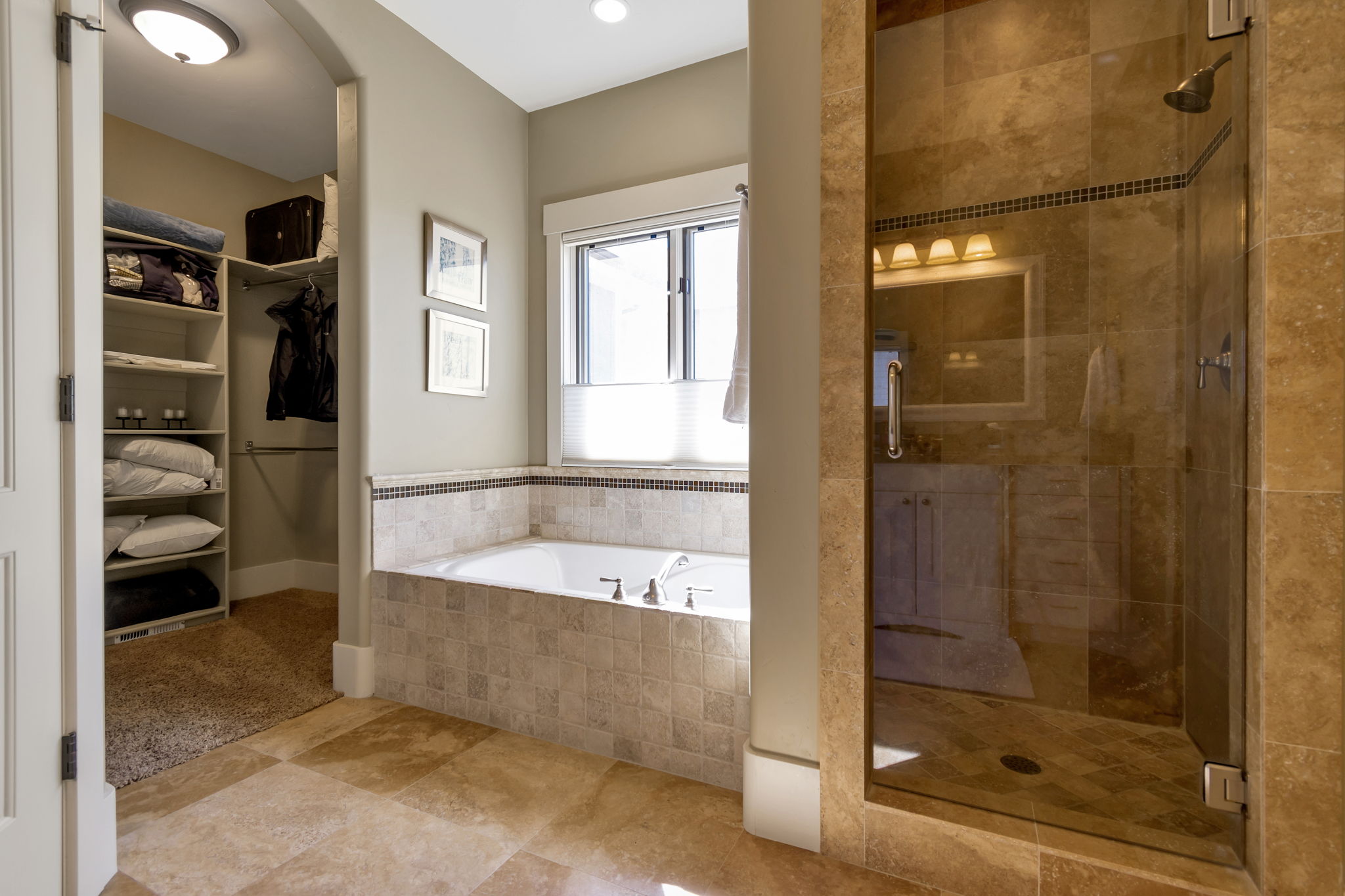 Bathroom featuring a shower stall, a bath, and a walk in closet