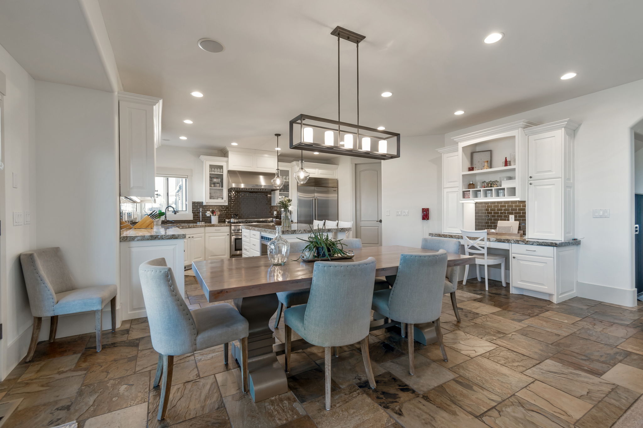 Dining room featuring stone tile flooring, built in desk, and recessed lighting