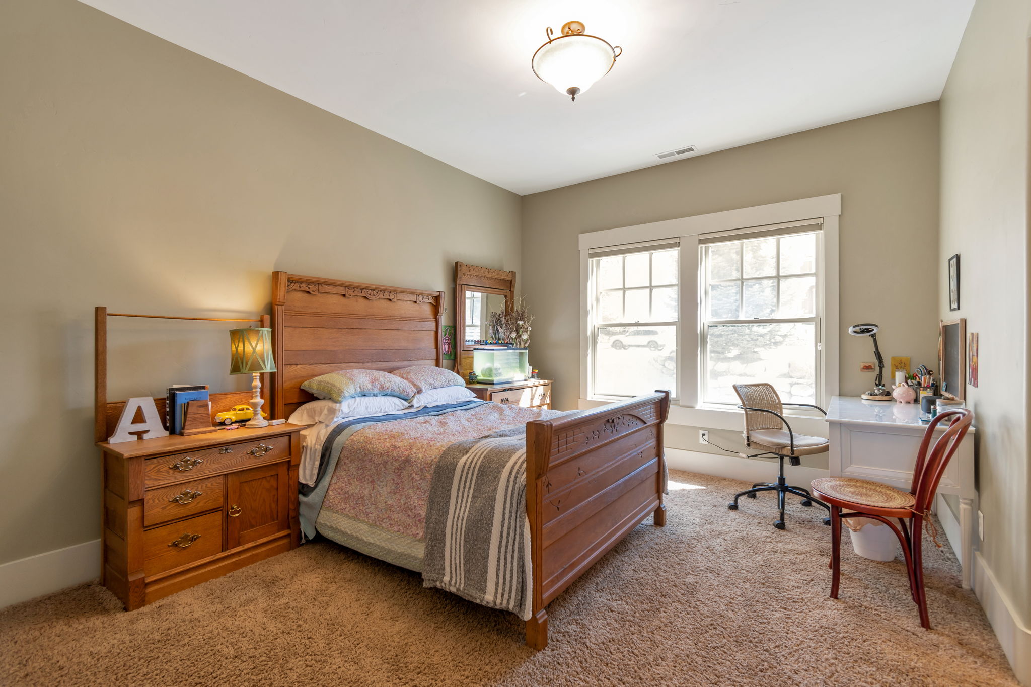 Bedroom featuring light carpet and a desk