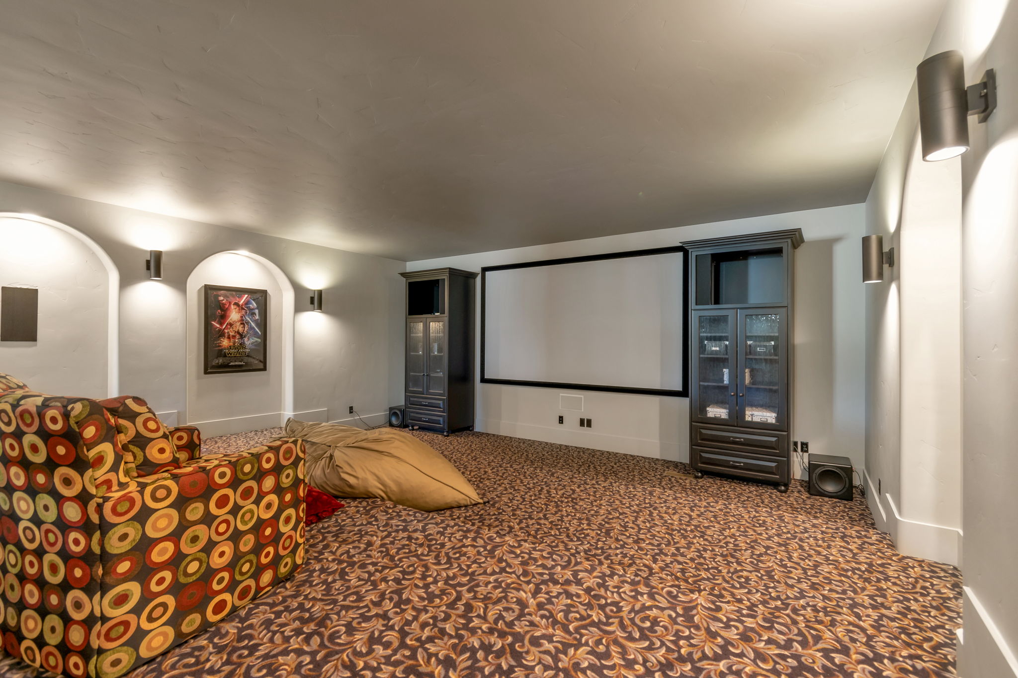 Cinema room with dark colored carpet and baseboards