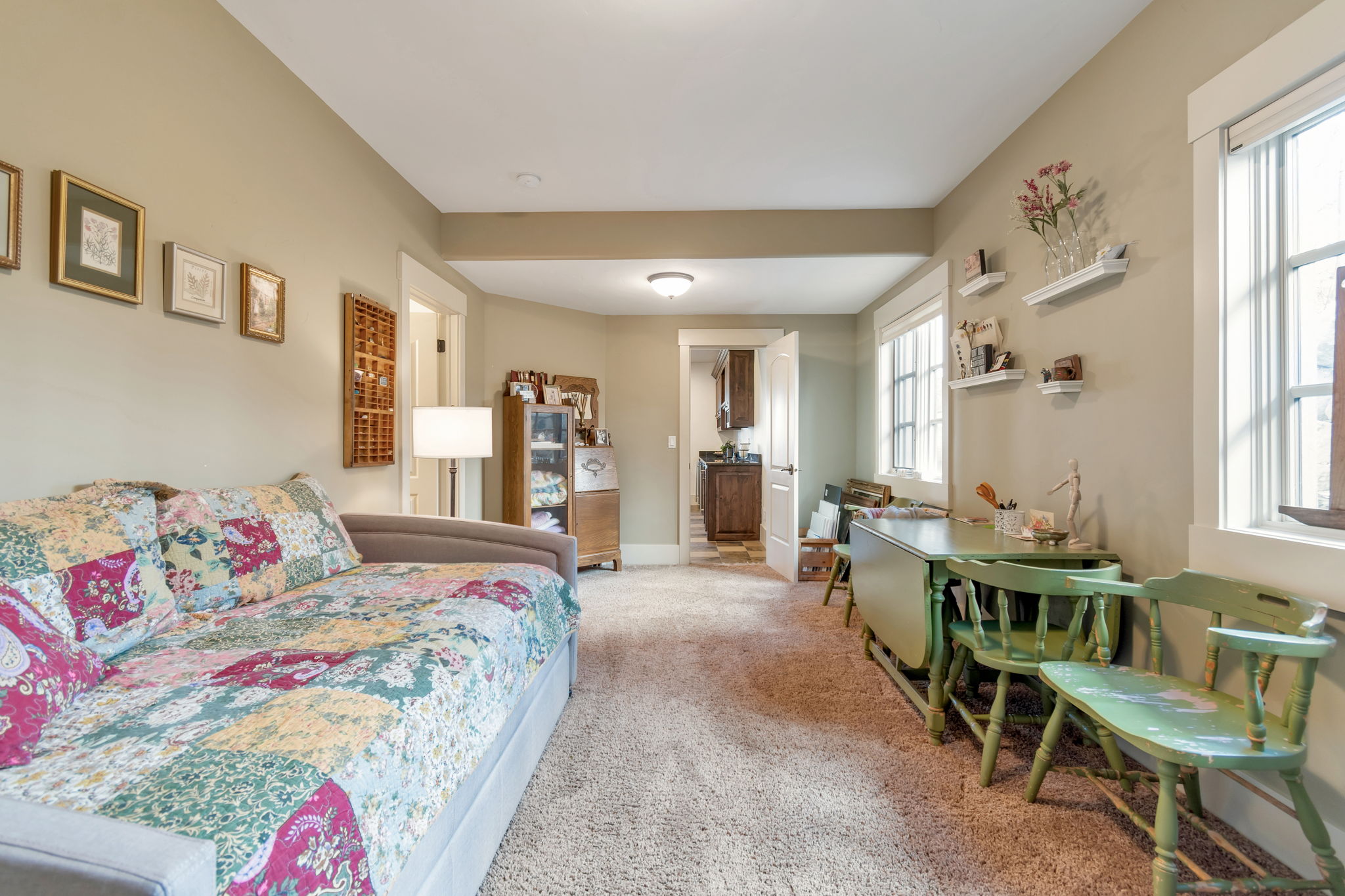 Bedroom featuring light carpet and multiple windows