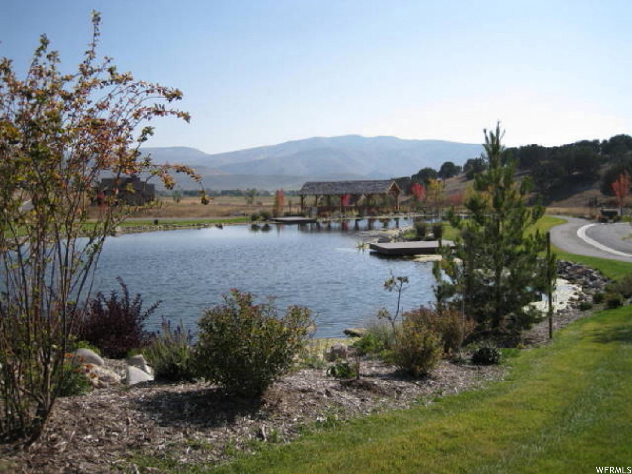 Water view featuring mountains and a boat dock
