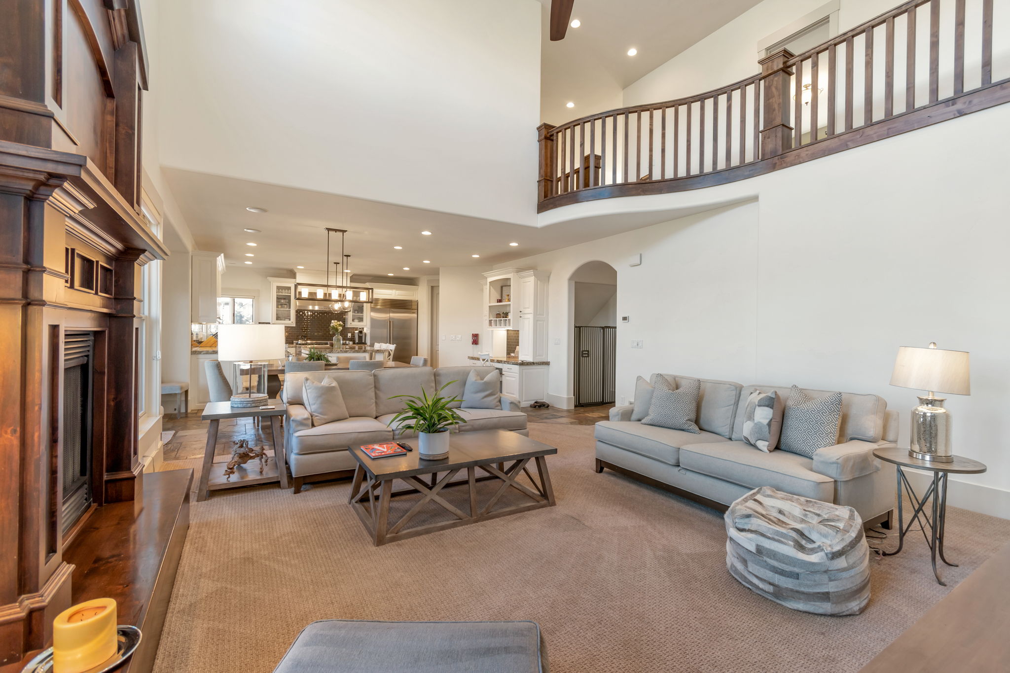 Living room featuring recessed lighting, arched walkways, a fireplace with raised hearth, and a high ceiling