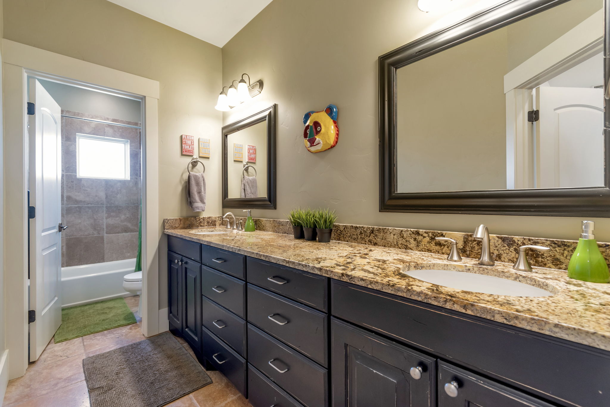 Bathroom with double vanity, bathing tub / shower combination, and light tile patterned floors
