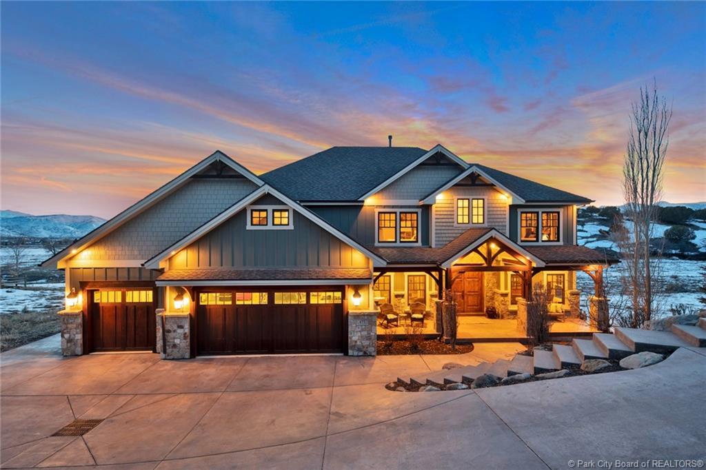 Craftsman house with covered porch, driveway, board and batten siding, stone siding, and roof with shingles
