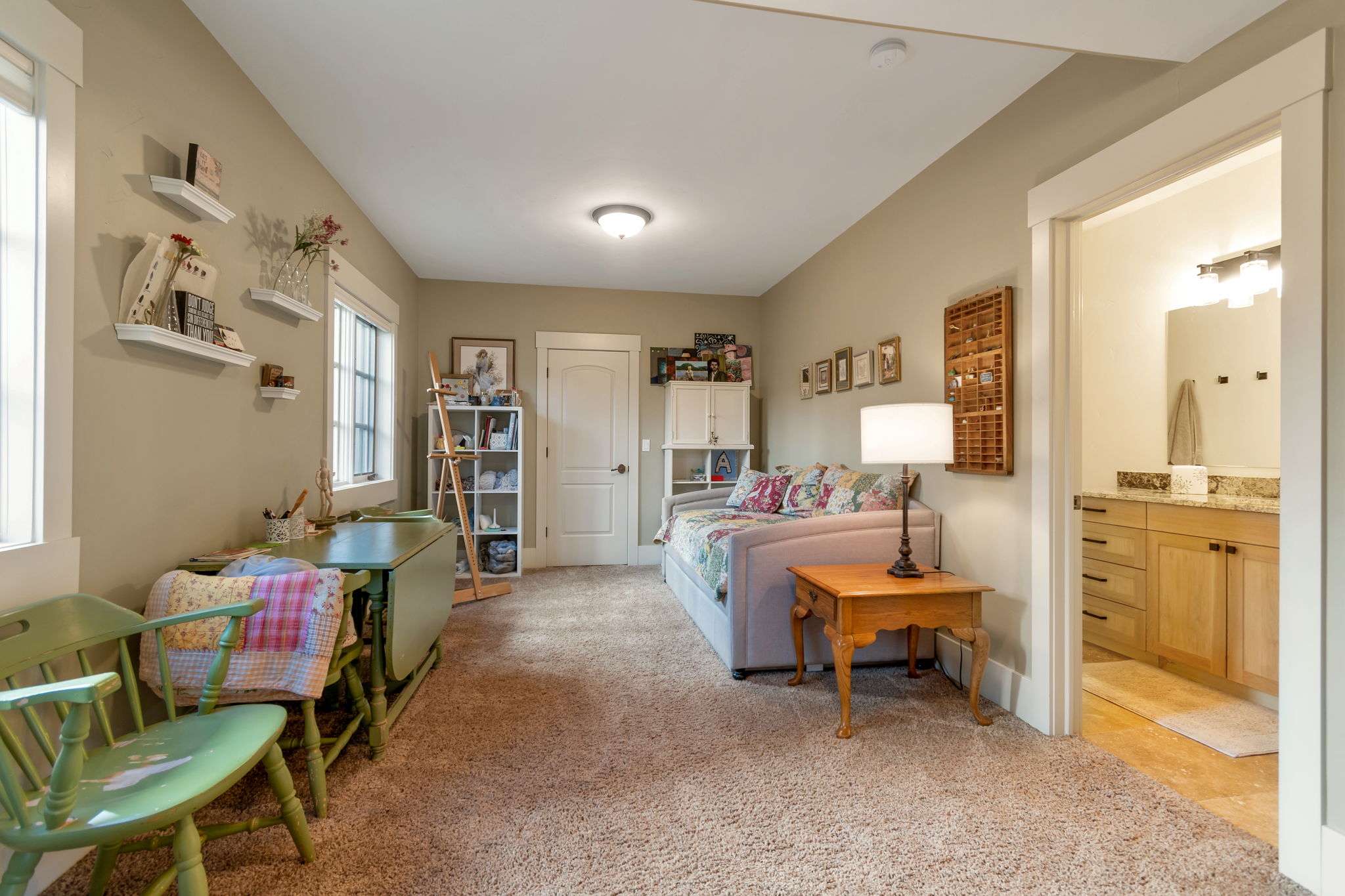 Bedroom featuring light carpet and connected bathroom