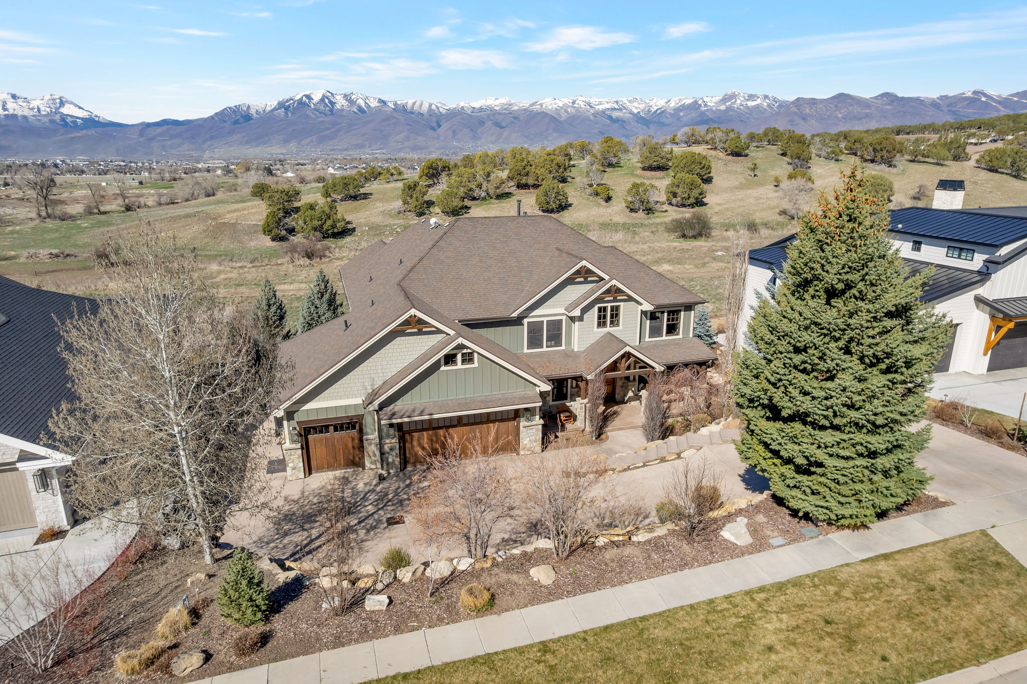 Craftsman house featuring stone siding, board and batten siding, a mountain view, and roof with shingles