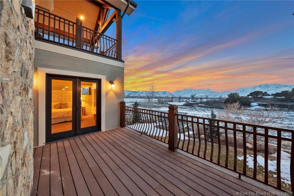 Snow covered deck with a mountain view and french doors