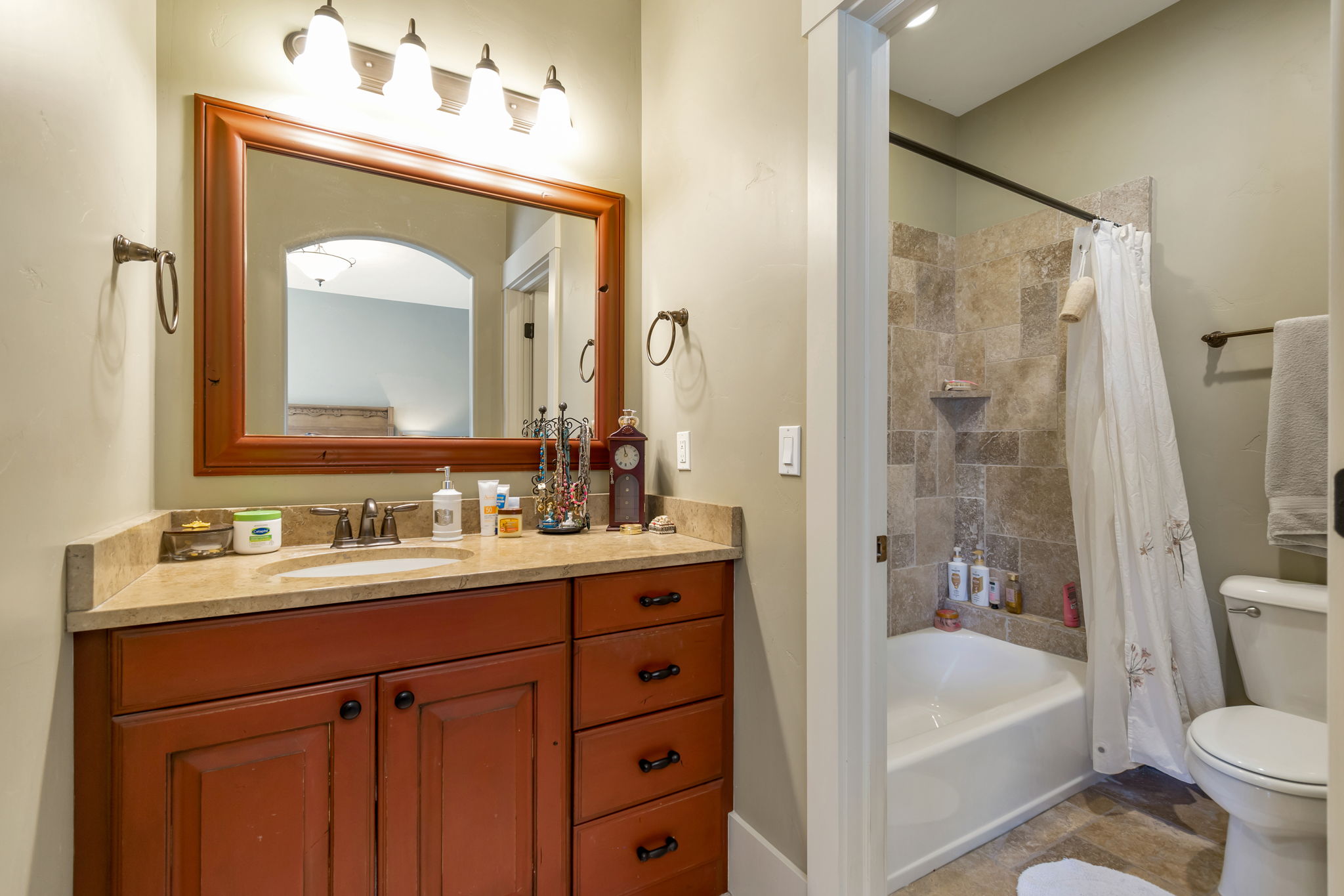 Bathroom featuring vanity and shower / bathtub combination with curtain