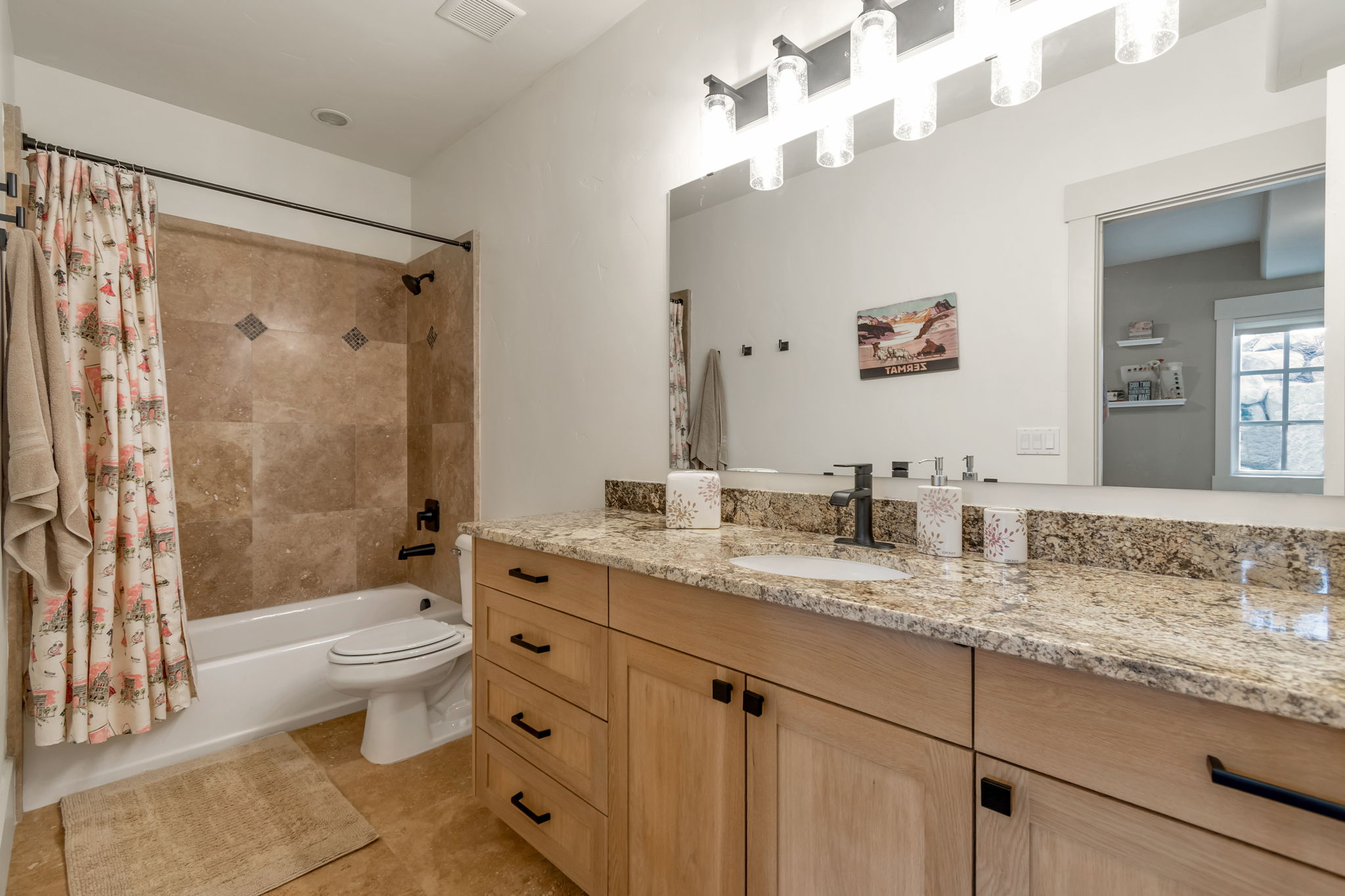Full bath featuring vanity, shower / tub combo with curtain, and light tile patterned floors