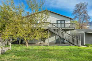 Rear view of property featuring a yard and a deck