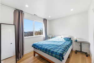 Bedroom with light wood-type flooring and recessed lighting