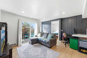 Living area with light wood finished floors, an office area, and recessed lighting