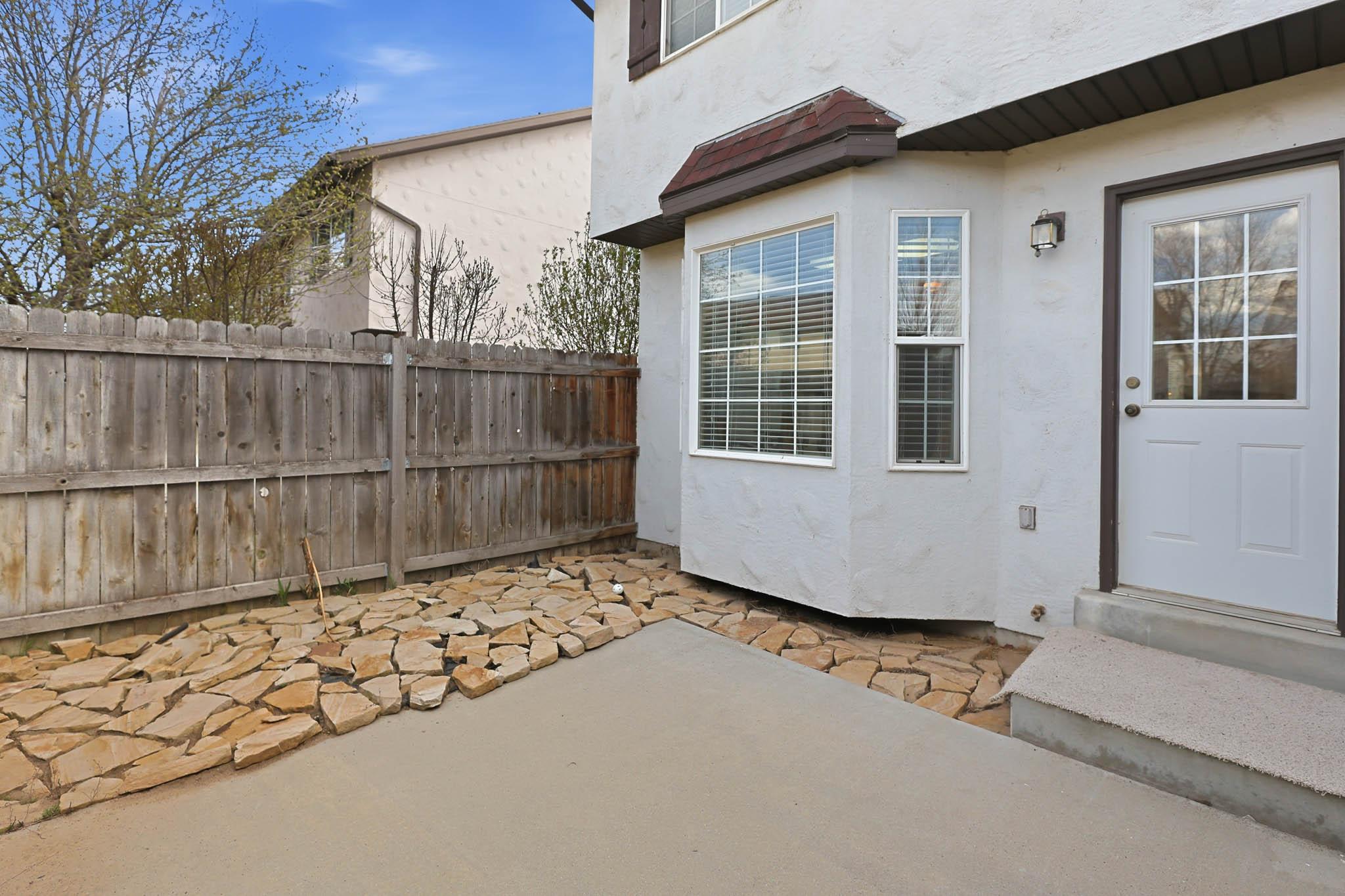 Back of Home With Large Patio and Bay Window