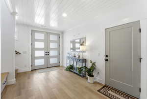 Entryway with light wood finished floors, wood ceiling, french doors, and recessed lighting