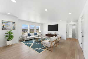Virtually Staged Living room featuring light wood finished floors and recessed lighting