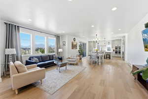 Living room with a mountain view, light wood-type flooring, and hanging lights