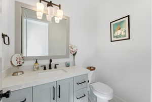 Half bathroom with vanity and toilet