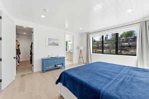 Primary Bedroom featuring light wood-type flooring, recessed lighting, ensuite bath, and a walk in closet with laundry hook ups