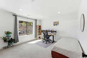 Carpeted bedroom with a desk and recessed lighting
