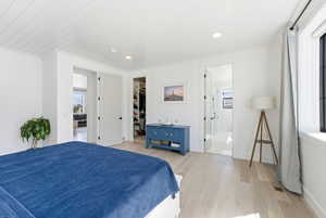 Primary Bedroom with light wood finished floors, a walk in closet, recessed lighting, and ornamental molding