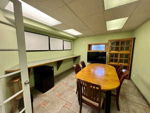 Dining area with stone tile flooring and a drop ceiling