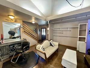 Living room featuring stairs and vaulted ceiling