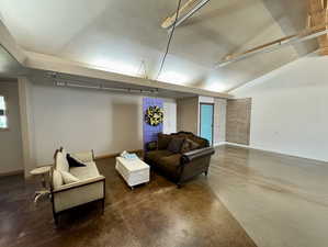 Sitting room featuring concrete floors and vaulted ceiling