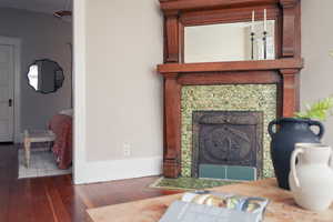 Living area featuring wood-type flooring and a tiled fireplace