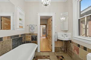 En -suite main level bedroom with a claw foot tub.