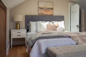 Bedroom with lofted ceiling and wood finished floors