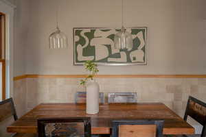 Dining room featuring tile walls and a wainscoted wall