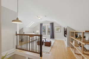 Additional living space featuring light wood-style flooring and a skylight
